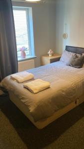 um quarto com uma cama com duas toalhas em Station Court em Swansea