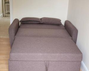 a couch sitting in a living room next to a wall at Cozy Central One Bedroom Flat in Reading