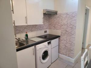 a kitchen with a washing machine and a sink at Cozy Central One Bedroom Flat in Reading