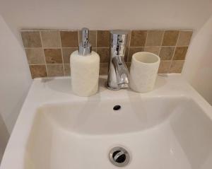 a white sink with two cups on top of it at Cozy Central One Bedroom Flat in Reading