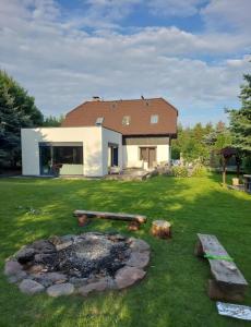 a house with a fire pit in the yard at VILLA DANUTA- WISELKA, direct at National Park, big garden, 4 bedrooms, private SAUNA in Wisełka