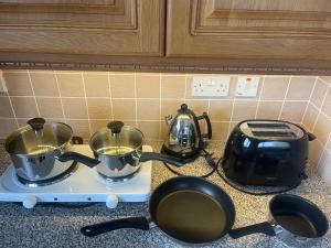 2 ollas y sartenes en una cocina en Music of the Sea- Isle of South Uist, HS8 5RF en Clachan