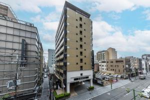 a tall building in the middle of a city at APA Hotel Kyoto Ekimae Chuoguchi in Kyoto