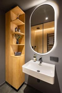y baño con lavabo blanco y espejo. en Birzes dzīvoklis (Birzes condo), en Cēsis