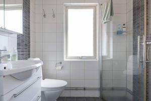a bathroom with a toilet and a sink and a window at WHITE & BRIGHT Room in a shared apartment in Gothenburg