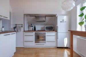 a kitchen with white appliances and a white refrigerator at WHITE & BRIGHT Room in a shared apartment in Gothenburg