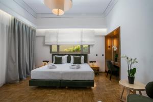 Un dormitorio con una cama grande y un escritorio. en Rodi Luxury Apartment, en Rodas