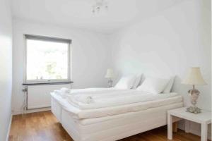 a white bed in a white room with a window at WHITE & BRIGHT Room in a shared apartment in Gothenburg