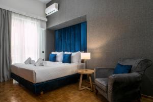 Habitación de hotel con cama y silla en Rodi Luxury Apartment, en Rodas