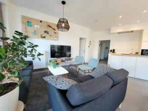 un soggiorno con divano blu e una cucina di Family apartment on the ground floor with terrace - Panne A Côte a De Panne