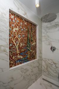 baño con una gran pintura en la pared en Rodi Luxury Apartment, en Rodas