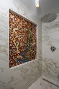 baño con una gran pintura en la pared en Rodi Luxury Apartment en Rodas