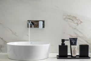 lavabo en el baño con 2 productos en una encimera en Rodi Luxury Apartment en Rodas
