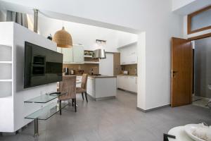 a kitchen with white cabinets and a dining room at Rodi Luxury Apartment in Rhodes Town