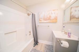 a white bathroom with a sink and a shower at Newly renovated Midtown Gem in Tyler +9 photos