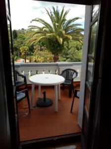 una mesa y sillas en un balcón con una palmera en Villa Alicia LA PERLA INDIANA, en Salas