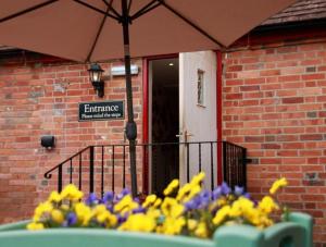 a table with purple and yellow flowers and an umbrella at The Tally Ho in Hungerford