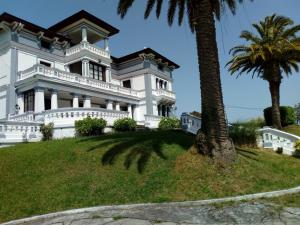 una gran casa blanca en una colina con una palmera en Villa Alicia LA PERLA INDIANA, en Salas