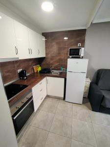 uma pequena cozinha com armários brancos e um lavatório em Apartament Goleta em Torrevieja