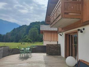 a wooden deck with chairs and tables on a house at Appartement Samoëns, 3 pièces, 4 personnes - FR-1-642-77 in Samoëns