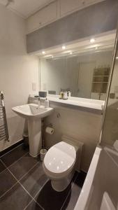a bathroom with a white toilet and a sink at Escape To The City in London
