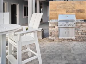 a white chair and a table and a stove on a patio at stayAPT Suites Chattanooga-Ooltewah/VW in Ooltewah