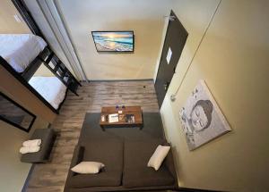 Habitación pequeña con sofá, cama y mesa. en Boxstel - Modern Stay Hotel Downtown El Paso en El Paso