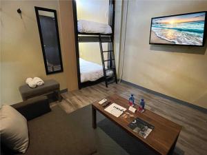 a living room with a couch and a coffee table and bunk beds at Boxstel - Modern Stay Hotel Downtown El Paso in El Paso