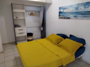 een slaapkamer met een geel bed in een kamer bij LE DOMAINE DE LA PETITE SUCRERIE in Vieux-Habitants