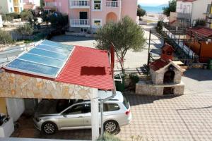 un coche estacionado junto a una casa con techo solar en Apartman Orange s pogledom na more i 50m od plaže, en Vodice