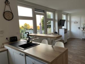 a kitchen with a counter top and a kitchen with windows at Le petit paradis in Cassel +66 photos