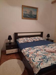 een slaapkamer met een bed en een foto aan de muur bij Apartman PIK in Karlobag
