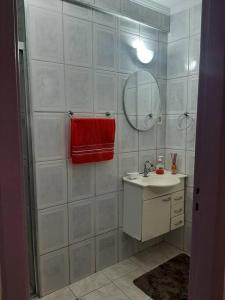 baño con lavabo y toalla roja en Apto Amplo, confortável, bem localizado, Astúrias en Guarujá