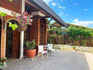 um pátio com cadeiras e uma mesa com flores em Casa hotel Mateguadua em Apartadó