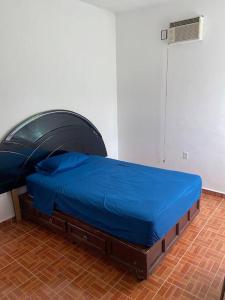 Ce lit se trouve dans un dortoir doté d'un couvre-lit bleu. dans l'établissement A big house for a big time., à La Joya