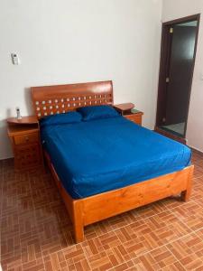 - une chambre avec un lit en bois et des draps bleus dans l'établissement A big house for a big time., à La Joya