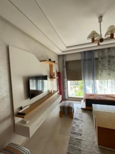 a large living room with a couch and a tv at relax à Costa Beach in Bouznika