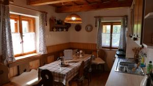 a kitchen with a table in a room with windows at Cesta z mesta na Huty in Huty