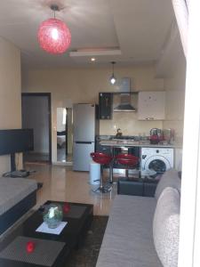 Booking house في أغادير: مطبخ وغرفة معيشة مع أريكة وطاولة