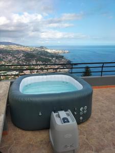 a hot tub sitting on top of a balcony at Casa do Pico in Câmara de Lobos