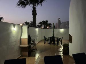 eine Terrasse mit einem Tisch und Stühlen in der Nacht in der Unterkunft Villa Karisa in Playa Blanca