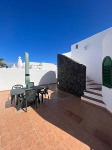 eine Terrasse mit einem Tisch und Stühlen neben einem Gebäude in der Unterkunft Villa Karisa in Playa Blanca