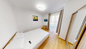 a bedroom with a white bed and a window at Serenity Retreats VRT in Sibiu
