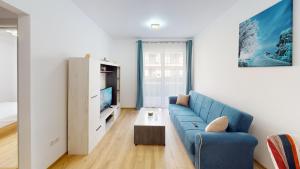 a living room with a blue couch and a tv at Serenity Retreats VRT in Sibiu