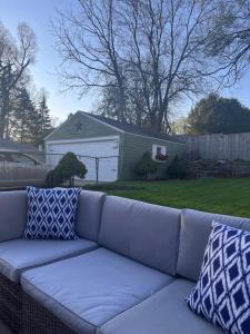 a gray couch with two pillows sitting in a yard at Cozy Cape Cod in Grand Rapids