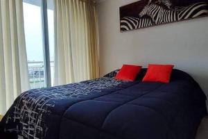 a bedroom with a blue bed with two red pillows at Sor Vicenta Suites in San Carlos de Purén