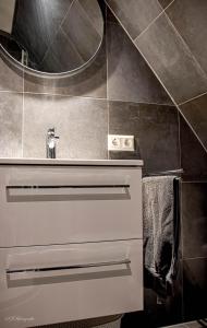 ein Badezimmer mit Waschbecken und Spiegel in der Unterkunft Appartement de 3 haasjes in landelijke omgeving. in Wijdenes