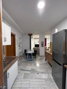 a kitchen with a refrigerator and a table in it at Apartamento Cortijo Pontiví in Salobreña