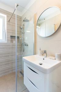Baño blanco con lavabo y espejo en New 4 star Room M&A in town Cres en Cres