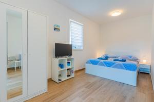 1 dormitorio con 1 cama azul y TV en New 4 star Room M&A in town Cres en Cres